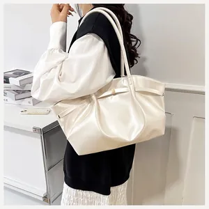 Détail du sac seau plissé blanc crème avec fermoir doré et texture en cuir lisse