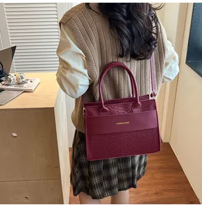 Elegante borsa a mano bordeaux trama coccodrillo con scritte dorate per donne