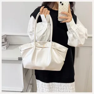 Détail du sac seau plissé blanc avec fermoir doré et cuir à l'aspect perlé brillant