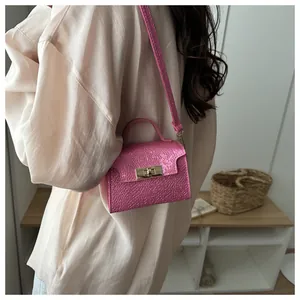 Detail of metallic rose pink crocodile texture mini bag with golden twist lock