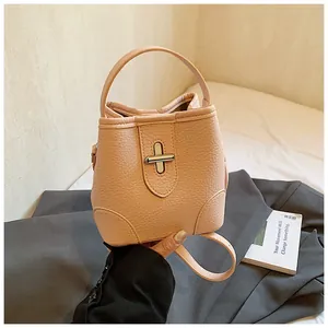 Detail of peach pink bucket bag featuring litchi texture leather and silver swivel lock