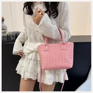 Detail of light pink woven tote bag with Intrecciato pattern and adjustable strap