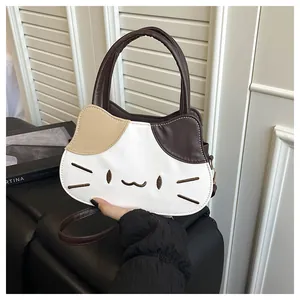 Detail of a cat-shaped handbag featuring contrast color ears and embroidered face details