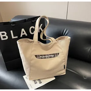 Dettaglio della borsa tote in tela con patch a quadri marroni e scritta Midolai Bag
