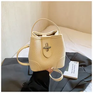 Detail view of cream bucket bag with lychee texture and silver metal twist lock