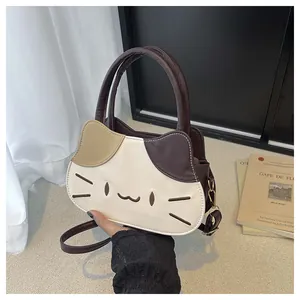 Close-up of cat-shaped crossbody bag featuring tricolor leather and embroidery details