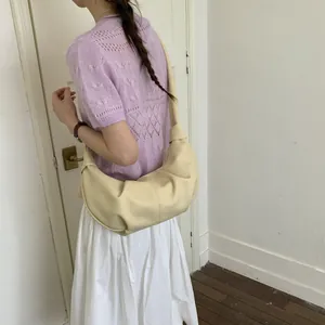 Detailansicht der cremefarbenen Halbmond-Hobo-Tasche mit eleganten Falten und Schultergurt