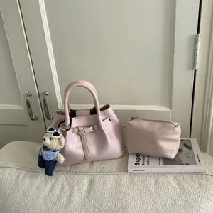 Detail view of light pink bucket bag set with decorative belt strap and bear charm