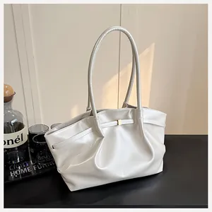 Détails d'un sac cabas plissé beige en cuir avec boucle dorée et fines poignées