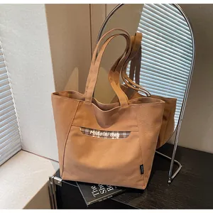 Dettaglio della borsa tote in tela con testo Midolai Bag e motivo scozzese vicino a uno specchio