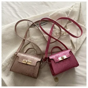 Detail of metallic snakeskin texture small square bags with metal turn-lock closures