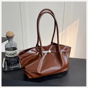 Détail d'un sac seau vintage en cuir marron avec design plissé et fermoir métallique