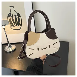 Detailed view of cat-shaped crossbody bag with color-block stitching and gold hardware