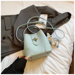 Detail of light blue bucket bag showing lychee grain leather texture and metal swivel lock