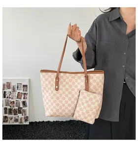 Detail of the large tote bag set with monogram print and contrasting brown leather straps