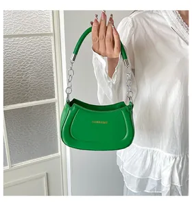 Detail einer hellgrünen Handtasche mit silberner Metallkette und modischem Text