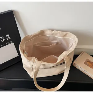 Dettaglio interno della borsa tote in tela beige con tasca a zip e ampio scomparto