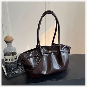 Détail du cabas en cuir marron foncé avec boucle métallique et texture plissée