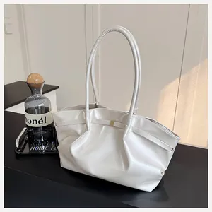 Détail du sac seau en cuir PU crème avec finition nacrée et boucle dorée élégante