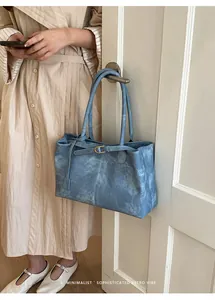 Detail of blue retro marbled tote bag featuring a slim belt and gold metal buckle