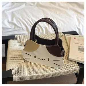 Close-up of the cat-shaped PU leather handbag with contrast stitching on a woven chair
