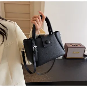 Detailansicht der schwarzen Handtasche aus Leder mit Lychee-Maserung und Metallbeschlägen