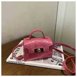 Detailed view of pink snake-pattern mini bag with gold lock and adjustable strap