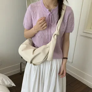 Schicke beige Mondsichel-Tasche mit geknotetem Gurt an Model im Freizeit-Look