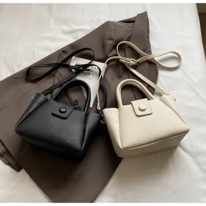 Detail von Beuteltaschen aus Leder mit Lychee-Muster in Schwarz und Beige mit runder Schnalle