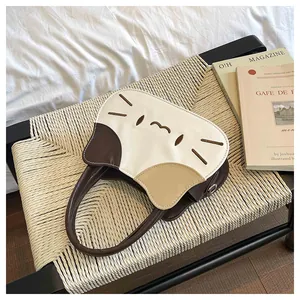 Detail of cute tricolor cat-shaped handbag with fine stitching and leather patchwork