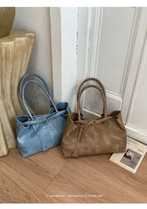 Detail view of morandi blue and caramel tote bags featuring premium frosted leather texture