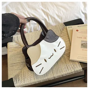 Close-up of the embroidered cat face details and contrast stitching on the PU leather handbag