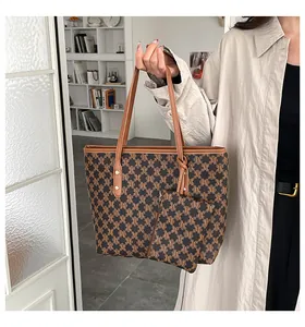 Detail view of retro tote bag set with M-letter monogram print and brown leather handles