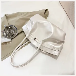 Détail de la texture du sac seau blanc crème avec des plis en cuir souple