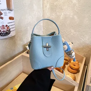 Light blue lychee pattern leather bucket bag with cute bear charm and twist-lock closure