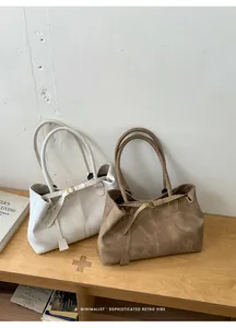 Detailed shot of retro matte leather tote bags in cream and dark coffee on a wooden bench