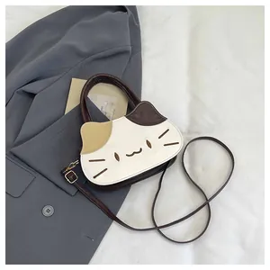 Detailed close-up of a cat-shaped handbag with embroidery and adjustable brown strap
