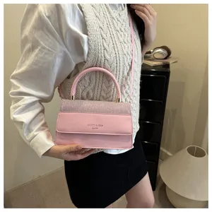 Detail of pink crossbody bag featuring sparkling rhinestone flap and elegant top handle