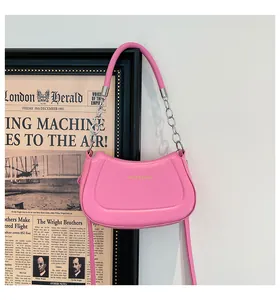 Detail der rosa halbkreisförmigen Ledertasche mit Silberkette und Goldaufdruck