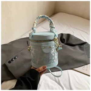 Dettaglio borsa a secchiello celeste con pizzo e manico avvolto in seta blu