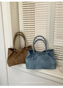 Detail view of vintage leather tote bags in brown and blue with minimalist buckle straps