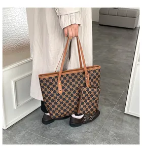 Detail of retro monogram tote bag set with brown leather straps and matching pouch