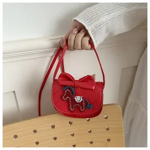 Detail van rode kleine vierkante tas met 3D-strik, borduurwerk en ruitstiksels