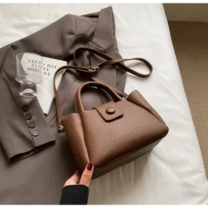 Nahaufnahme der braunen Handtasche mit Lychee-Muster auf einem Sakko mit Dekoration