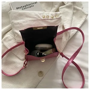 Internal capacity of pink leather mini square bag with cosmetics and metal twist lock