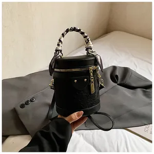 Dettaglio borsa a secchiello in pizzo nero con manico in foulard di seta e hardware dorato