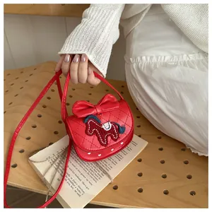 Detailweergave van rode lederen mini crossbodytas met paardenborduursel en strikdecoratie