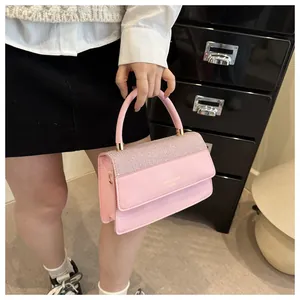 Detail of pink PU leather handbag with shimmer fabric and gold metal accents