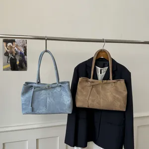 Detail of minimalist tote bags in grey-blue and khaki with premium matte leather texture