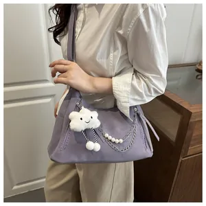 Detalle del bolso de hombro lavanda con cadena de plata perlas y colgante nube